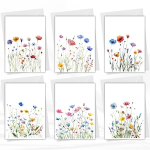 Könnte beinhalten: Sechs Grußkarten mit Aquarellillustrationen von Wildblumen in verschiedenen Farben, darunter Rot, Blau, Gelb und Lila. Jede Karte zeigt eine andere Blumenanordnung vor weißem Hintergrund, mit passendem Umschlag.