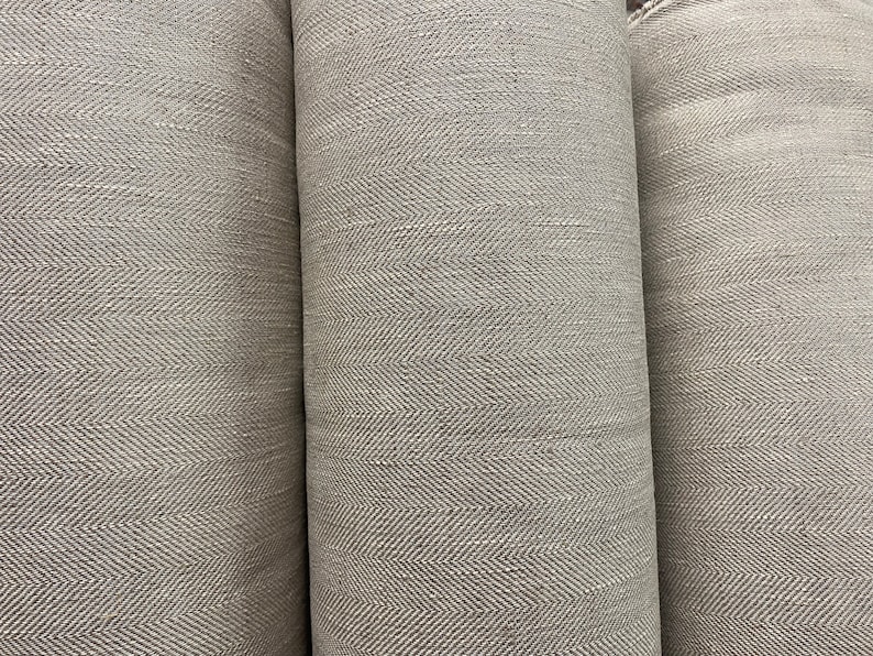 May include: Three rolls of gray fabric with a herringbone pattern.