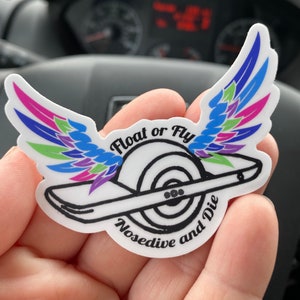 Könnte beinhalten: Ein weißer Aufkleber mit einer Schwarzweißillustration eines einrädrigen Elektrofahrzeugs mit Flügeln. Der Text "Float or Fly Nosedive and Die" ist um das Fahrzeug herum geschrieben.