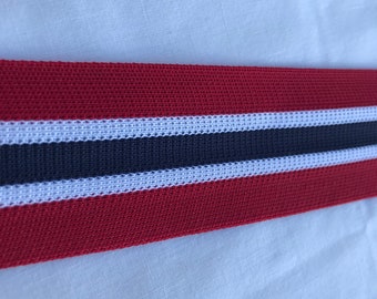 May include: Red, white, and navy blue striped elastic band. The band is woven with a textured pattern.