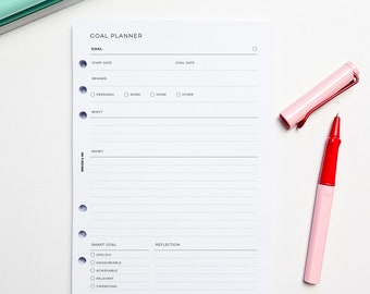 May include: A white goal planner with a black and gray gradient design. The planner has sections for goal setting, start date, goal date, reward, why, how, smart goal, and reflection. The planner has a dotted line design and a hole punch on the left side.