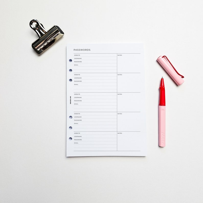 a notepad with a red pen next to a stapler