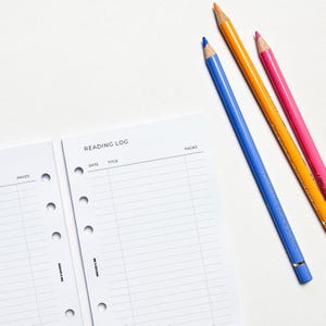 two pencils and a notepad on a table