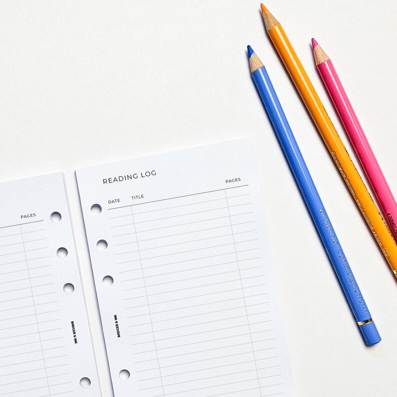 two pencils and a notepad on a table