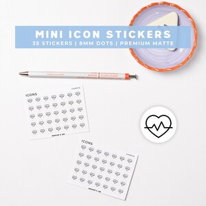 May include: Two square sheets of white mini icon stickers featuring black heart-shaped EKG pulse line designs, a single circular sticker with a heart EKG icon, a white pen with orange accents, and a small lavender dish with an orange scalloped rim.