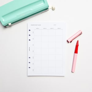 May include: A white exercise plan printable with a grid layout for tracking workouts. The printable has columns for each day of the week and rows for each week of the month. The printable has the text "EXERCISE PLAN" at the top and "MONTH" at the top right corner. The printable is on a white surface with a pink and red pen.