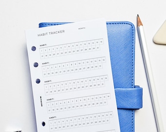 May include: A white habit tracker with five sections for tracking habits. Each section has a heading "HABIT:" and a grid of numbers from 1 to 31, representing the days of the month. The tracker is designed for use with a disc-bound planner.