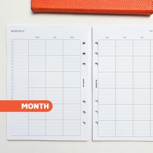 May include: White monthly planner pages with a grid layout for scheduling. The pages are pre-punched for a binder and include the days of the week. An orange accent highlights the word "MONTH". An orange leather cover is visible at the top.