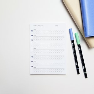 a notepad, pen, and notebook on a table