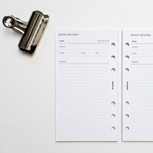 Peut inclure: Deux pages blanches de revue de livre avec un titre noir "BOOK REVIEW" et des lignes pour écrire le titre, l'auteur, le genre, les dates de début et de fin, et une revue. Les pages ont six trous sur le côté gauche pour un classeur.