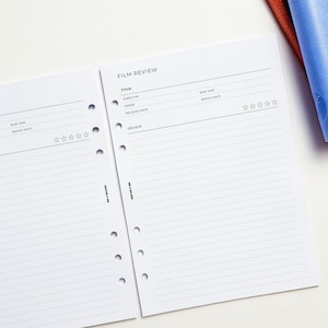 two lined pages of a notebook or planner, with a blank space for filling in information. There is a blue fabric item placed on the right side of the image.