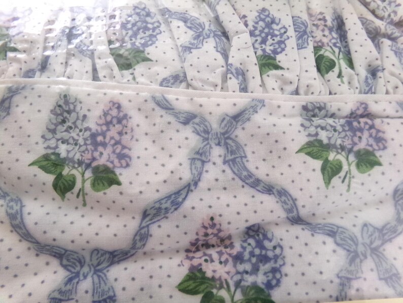 May include: White fabric with a blue and white polka dot pattern and a floral design featuring lilac flowers and blue ribbons.