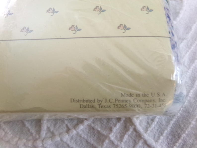 May include: A white background with a floral pattern and text that reads "Made in the U.S.A. Distributed by J.C. Penney Company, Inc. Dallas, Texas 75265-9000, 72-31-455"