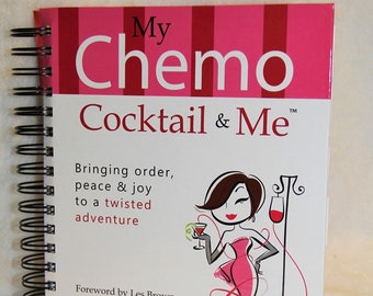 Pode incluir: Um caderno de espiral rosa e branco com o título "My Chemo Cocktail & Me" e uma ilustração de desenho animado de uma mulher com um vestido rosa segurando uma taça de coquetel. O texto abaixo do título diz "Bringing order, peace & joy to a twisted adventure". O caderno também inclui os nomes "Sharon Crews" e "Lucy Gross-Barlow".