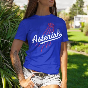 May include: A royal blue t-shirt with a white graphic of a red asterisk with rays of light and the word "Asterisk" in a white baseball font.
