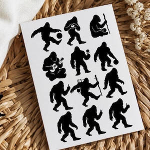 May include: A white rectangular sheet featuring twelve black silhouette illustrations of Bigfoot in various poses, including playing a ball, making a heart shape with hands, sitting with a staff, playing a guitar, holding a flower, and hiking.