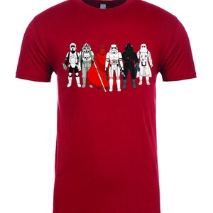 Puede incluir: Una camiseta roja con un gr&aacute;fico de siete stormtroopers de Star Wars en l&iacute;nea. Los stormtroopers llevan diferentes armaduras y cascos.