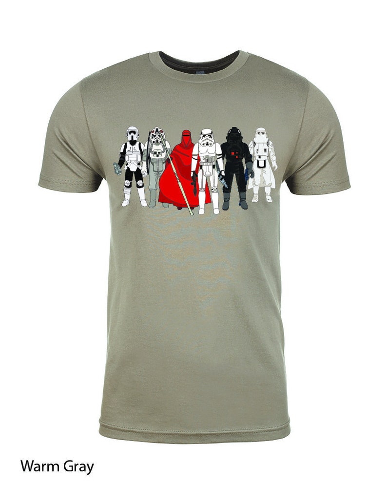 Puede incluir: Una camiseta gris c&aacute;lida con un estampado gr&aacute;fico de personajes de Star Wars. Los personajes est&aacute;n en fila y todos llevan sus trajes ic&oacute;nicos. Los personajes son de izquierda a derecha: un Stormtrooper, un Snowtrooper, un Guardia Real, un Stormtrooper, un piloto de caza TIE y un Stormtrooper.