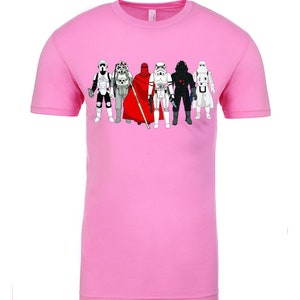 Puede incluir: Una camiseta rosa claro con un gr&aacute;fico de personajes de Star Wars, incluyendo Darth Vader, un Stormtrooper y un soldado rebelde.