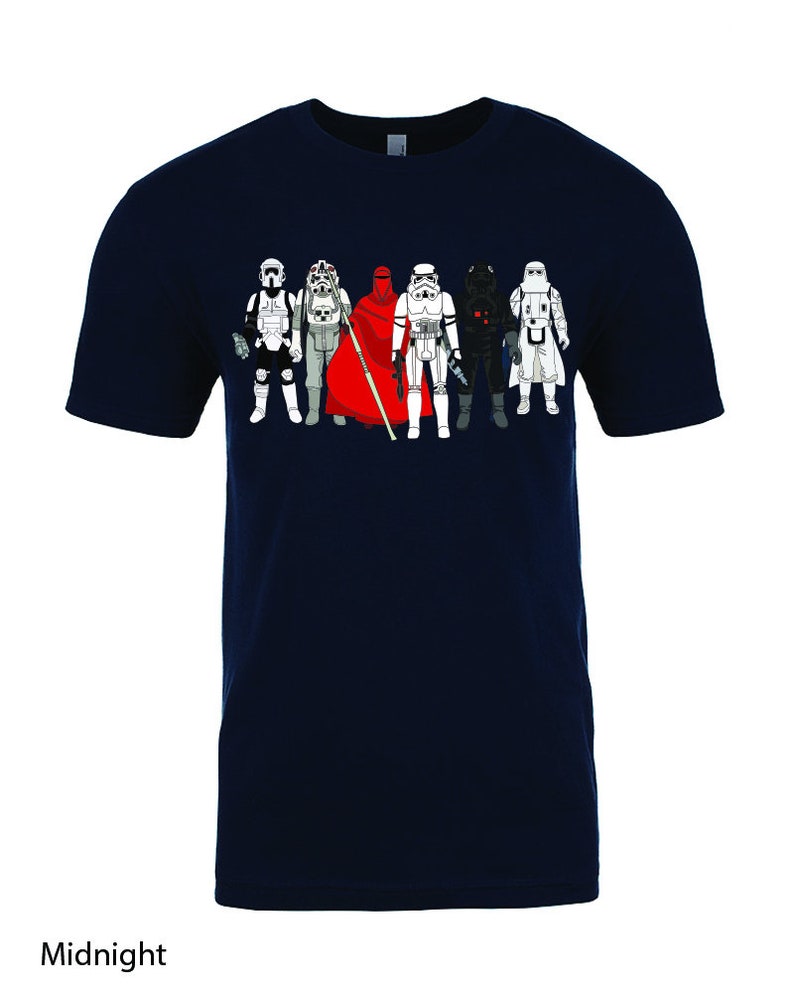 Puede incluir: Una camiseta azul marino con un gr&aacute;fico de siete personajes de Star Wars, incluyendo Darth Vader, un Stormtrooper y una figura con una capa roja.
