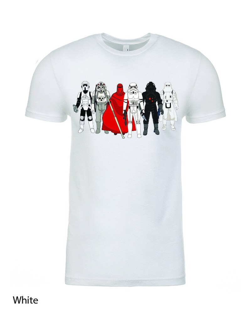 Puede incluir: Camiseta blanca con un gr&aacute;fico de personajes de Star Wars, incluyendo Darth Vader, un Stormtrooper y una figura con una t&uacute;nica roja.