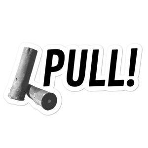 Puede incluir: Una pegatina en blanco y negro con la palabra "PULL!" en letras negras en negrita. Dos casquillos de escopeta gastados se muestran a la izquierda de la palabra.