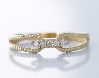 Könnte beinhalten: Ein zarter Goldring mit einem geflochtenen Band und einer Reihe kleiner Diamanten, die in der Mitte eingesetzt sind.
