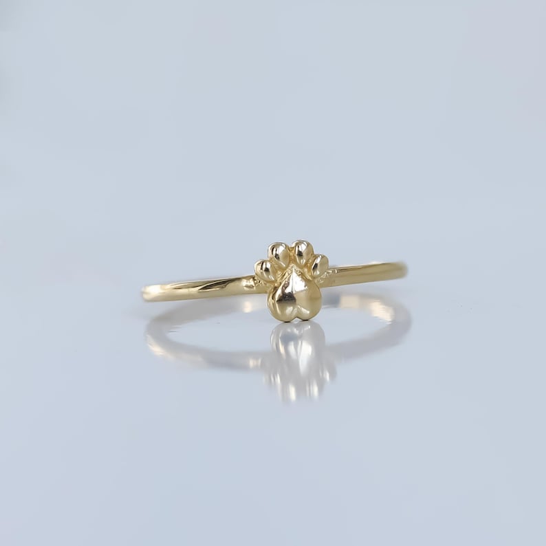 May include: A gold ring with a paw print design.