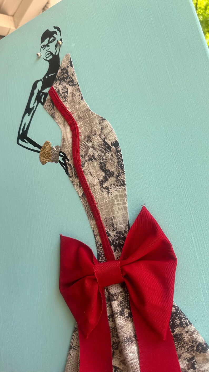 Puede incluir: Obra de arte de una figura estilizada con un vestido con estampado de piel de serpiente y un lazo rojo. La figura es en blanco y negro, con una pulsera dorada. El vestido tiene una cremallera roja sobre un fondo azul claro.