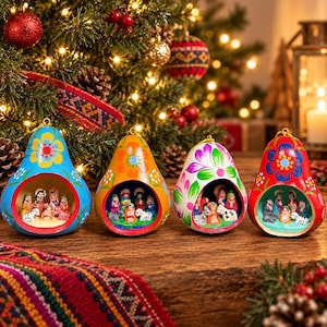 May include: Four pear-shaped gourd ornaments featuring hand-painted floral designs in blue, orange, white, and red. Each hollowed-out ornament contains a miniature nativity scene with small figurines of people and animals arranged inside.