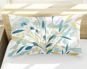 May include: Two white pillowcases with a blue and gold floral pattern. The pillowcases are on a white bed with a wooden headboard.