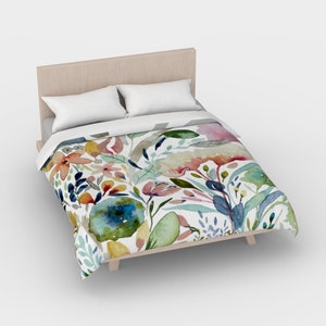 May include: A white duvet cover with a floral pattern featuring watercolor-style flowers in shades of pink, blue, green, yellow, and orange.