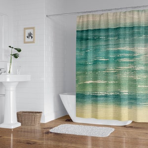 May include: A watercolor-style shower curtain featuring a blue and green ocean scene with a yellow sandy beach at the bottom.