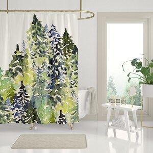 May include: A watercolor shower curtain featuring a forest scene with green, blue, and yellow trees. The curtain is hung on a gold shower rod in a bathroom setting.