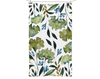 May include: A white kitchen towel with a watercolor pattern of green leaves and blue flowers.