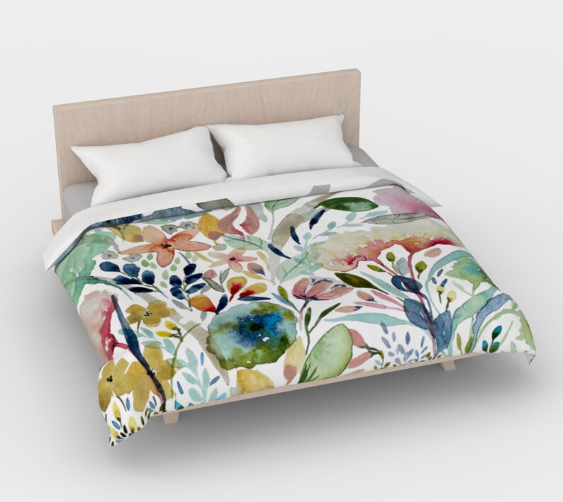 May include: A white duvet cover with a watercolor floral pattern featuring pink, yellow, blue, and green flowers and leaves.
