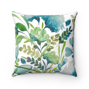 May include: A square throw pillow with a watercolor floral design featuring blue, green, and yellow flowers and leaves on a white background.