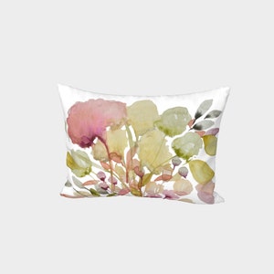 Puede incluir: Coj&iacute;n rectangular blanco con un dise&ntilde;o floral de acuarela. El dise&ntilde;o presenta hojas y flores rosas, amarillas y verdes. El coj&iacute;n tiene una est&eacute;tica suave y art&iacute;stica.