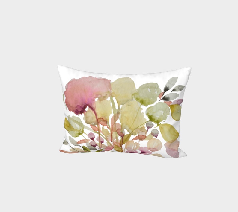 Puede incluir: Coj&iacute;n rectangular blanco con un dise&ntilde;o floral de acuarela. El dise&ntilde;o presenta hojas y flores rosas, amarillas y verdes. El coj&iacute;n tiene una est&eacute;tica suave y art&iacute;stica.
