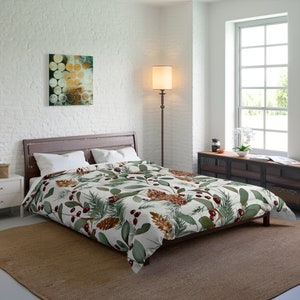 Könnte beinhalten: Ein Bett mit Holzrahmen und einer Bettdecke mit einem botanischen Muster aus grünen Blättern, braunen Tannenzapfen und roten Beeren auf weißem Hintergrund. Der Raum hat eine neutrale Farbpalette mit einem braunen Teppich und einer weißen Backsteinmauer.