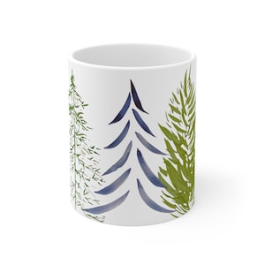 May include: White ceramic mug with a watercolor design of three stylized trees in shades of green and blue.