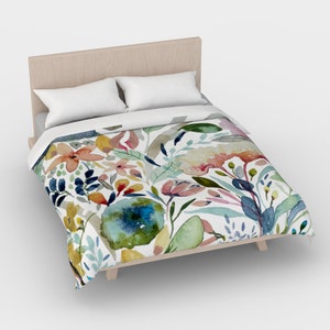 May include: A white duvet cover with a watercolor floral pattern featuring pink, blue, yellow, and green flowers and leaves.