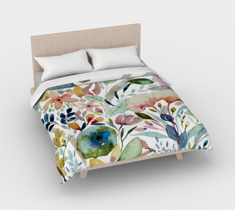 May include: A white duvet cover with a watercolor floral pattern featuring pink, blue, yellow, and green flowers and leaves.