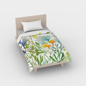 May include: A white twin-sized duvet cover with a watercolor floral print featuring blue, yellow, green, and orange flowers and leaves.