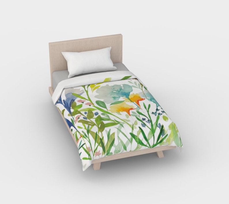 May include: A white twin-sized duvet cover with a watercolor floral print featuring blue, yellow, green, and orange flowers and leaves.