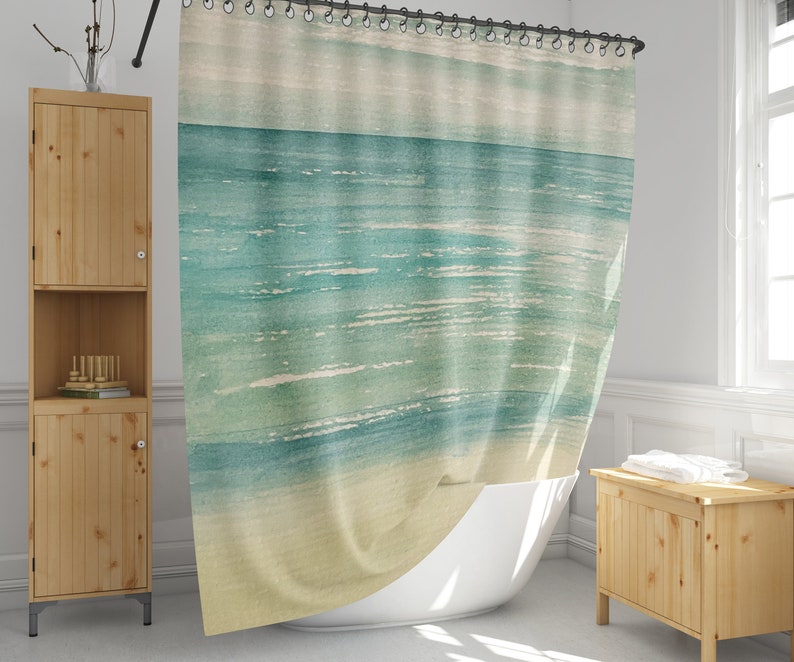 May include: A watercolor-style shower curtain featuring a blue and green ocean scene with white waves. The curtain has a light beige background.