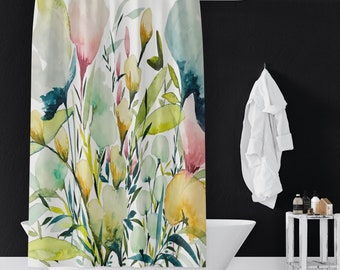 Könnte beinhalten: Duschvorhang mit floralem Aquarelldesign in Gelb-, Rosa-, Grün- und Blautönen. Der Vorhang hängt vor einer weißen Badewanne. Ein weißer Bademantel hängt an einem Haken an einer schwarzen Wand.