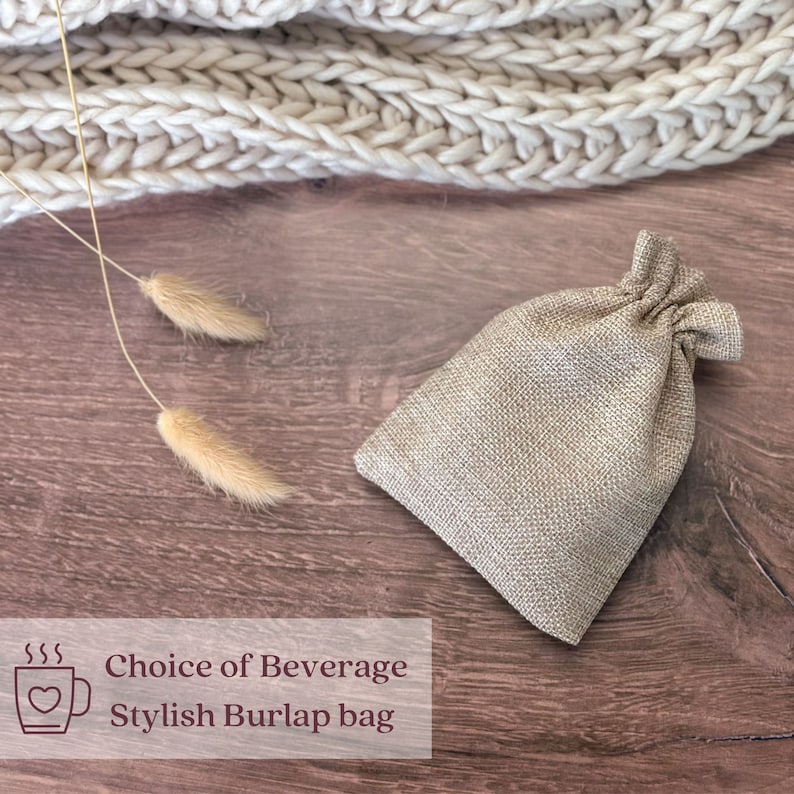 Puede incluir: Una peque&ntilde;a bolsa de arpillera beige con cierre de cord&oacute;n est&aacute; sobre una superficie de madera. La bolsa est&aacute; junto a un art&iacute;culo de punto beige y hierba ornamental seca. El texto de la imagen dice: "Choice of Beverage, Stylish Burlap bag."