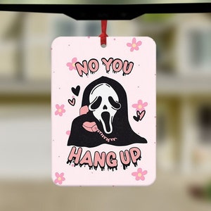 May include: A pink car air freshener with a white background. The air freshener features a cartoon ghost wearing a mask and holding a phone. The text "NO YOU HANG UP" is written in pink letters.