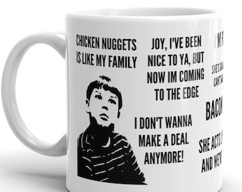 May include: White ceramic mug with a black and white image of a boy and text that reads "Chicken Nuggets is like my family", "Joy, I've been nice to ya, but now I'm coming to the edge", "I don't wanna make a deal anymore!" and "She acts and wet".